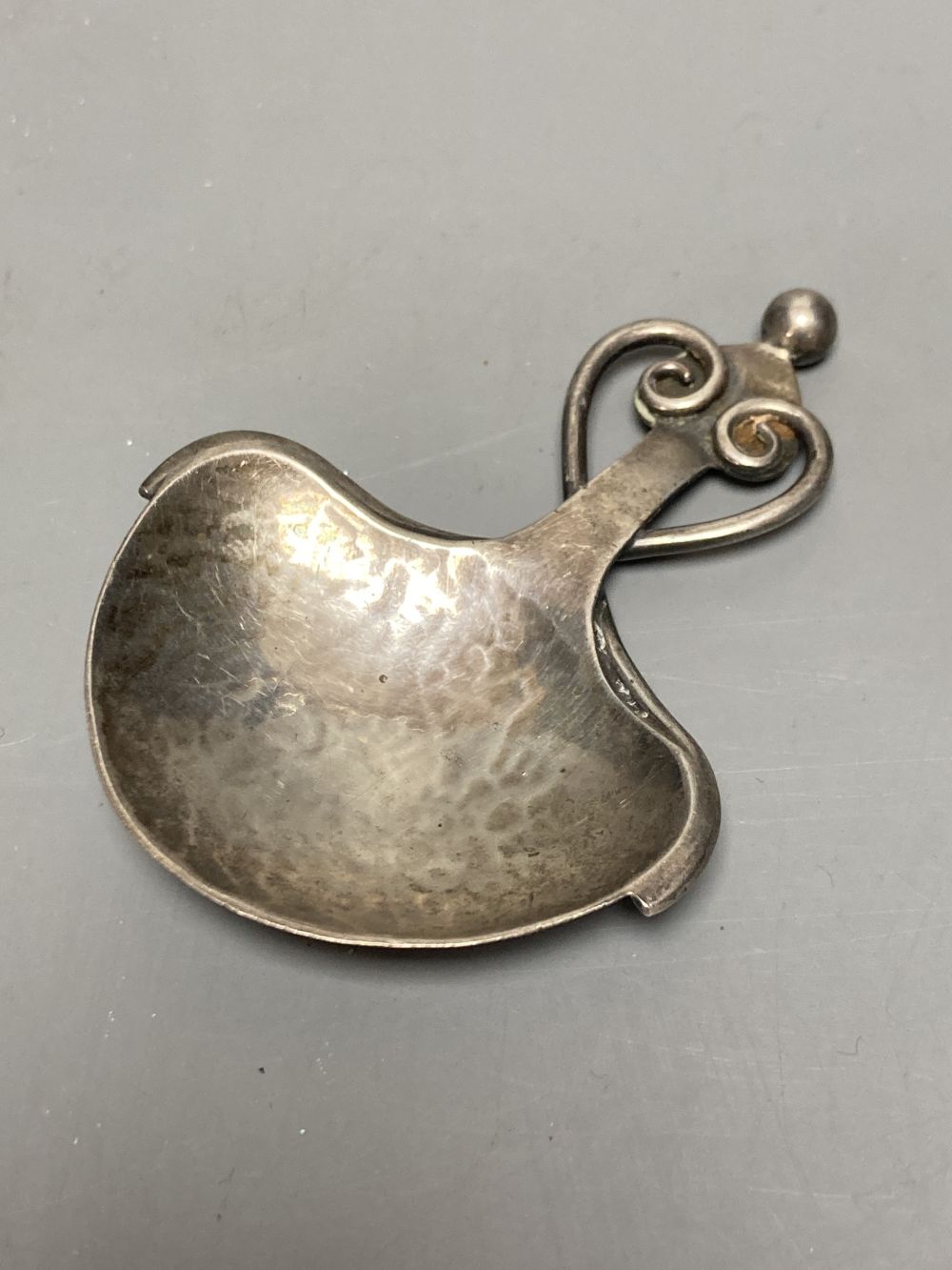 A George V Arts & Crafts planished silver caddy spoon by Albert Edward Jones, Birmingham, 1919, 78mm, 18 grams,